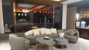Ein modernes Wohnzimmer mit einer Eckcouch, zwei Sesseln und zwei runden Couchtischen.