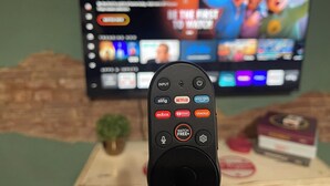 Un control remoto frente a un televisor que muestra diferentes servicios de transmisión.