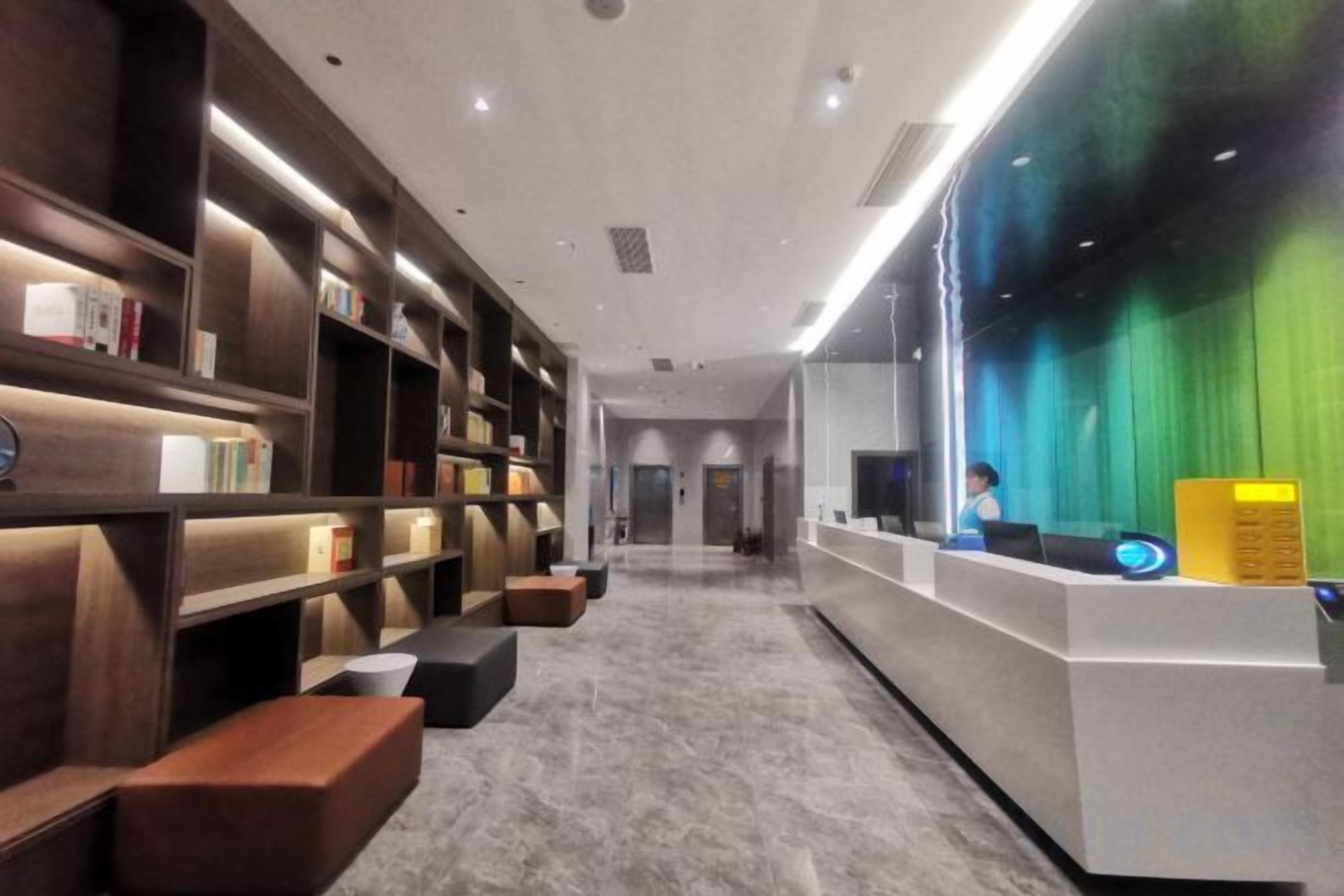 Un interior moderno con un mostrador de recepción, estanterías y una zona de estar.