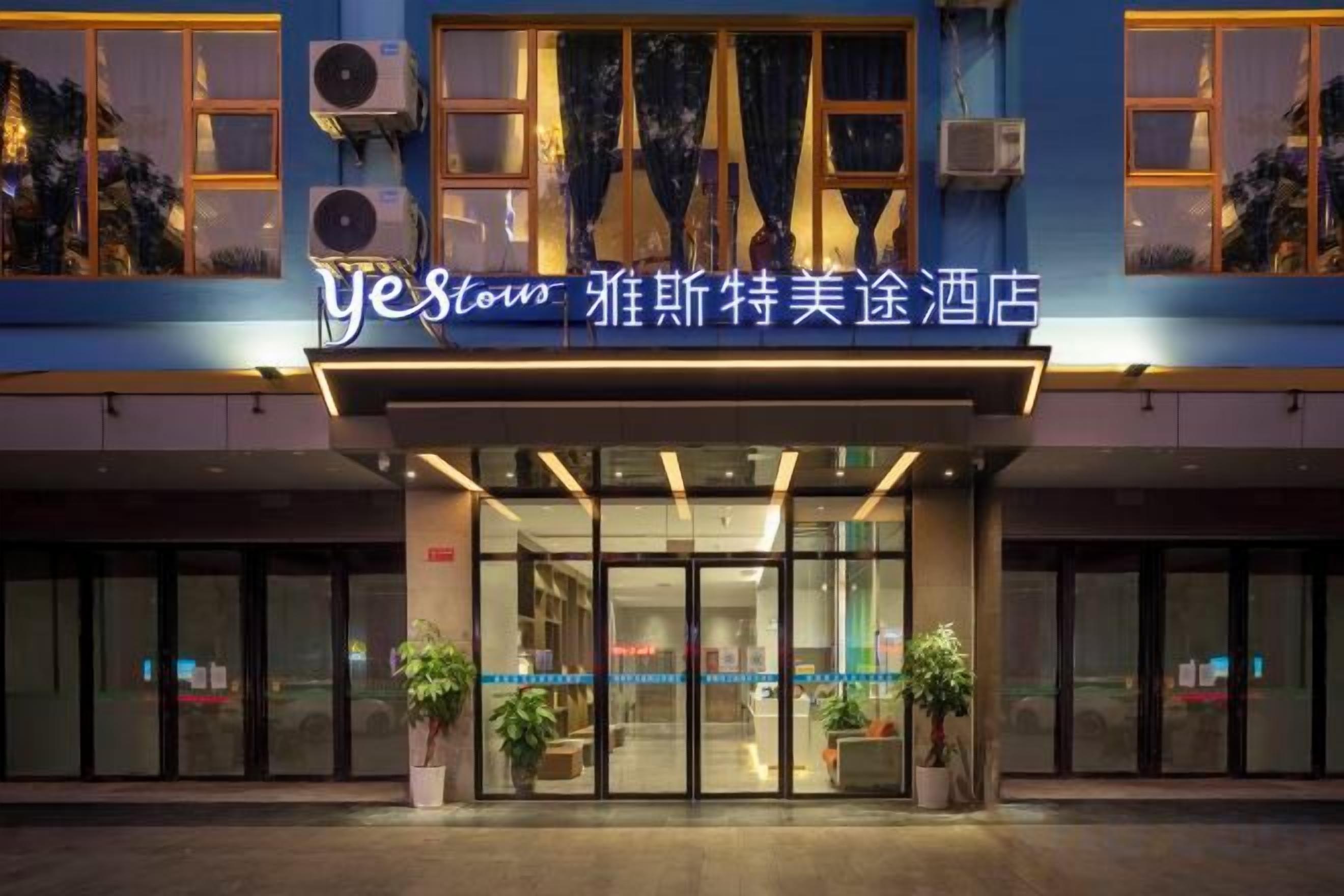 Entrada de un hotel con un letrero que dice 'yesstow' y '雅斯特美途酒店'.