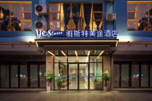 Entrada de un hotel con un letrero que dice 'yesstow' y '雅斯特美途酒店'.