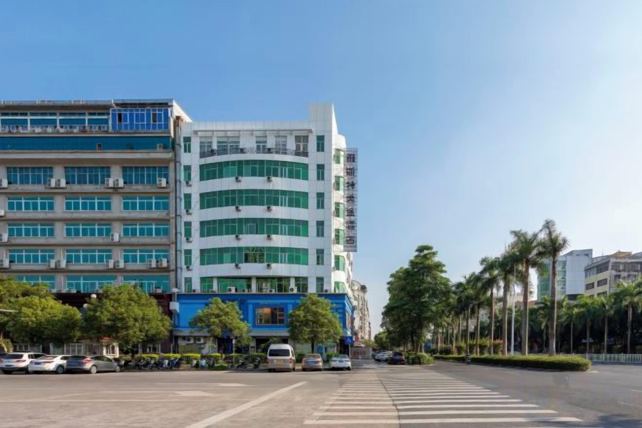 Un edificio de varios pisos con un diseño arquitectónico moderno, que combina fachadas de vidrio y concreto.