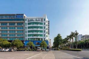 A multi-story building with a modern architectural design, featuring a mix of glass and concrete facades.