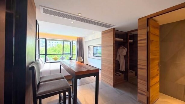 A modern interior with a wooden bench, a table, and a walk-in closet. - Radow E Hotel (Wenzhou Chezhan Avenue Times Square Branch) (Wenzhou)