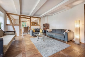 Ein geräumiges Wohnzimmer mit einer Couch, einem Couchtisch und einem Teppich.
