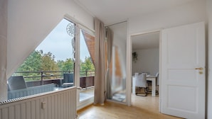 A room with a large window, a door, and a view of the outdoors. - Apartment 'Ferienwohnung Berti' with Balcony and Infrared Sauna (Heeßen)