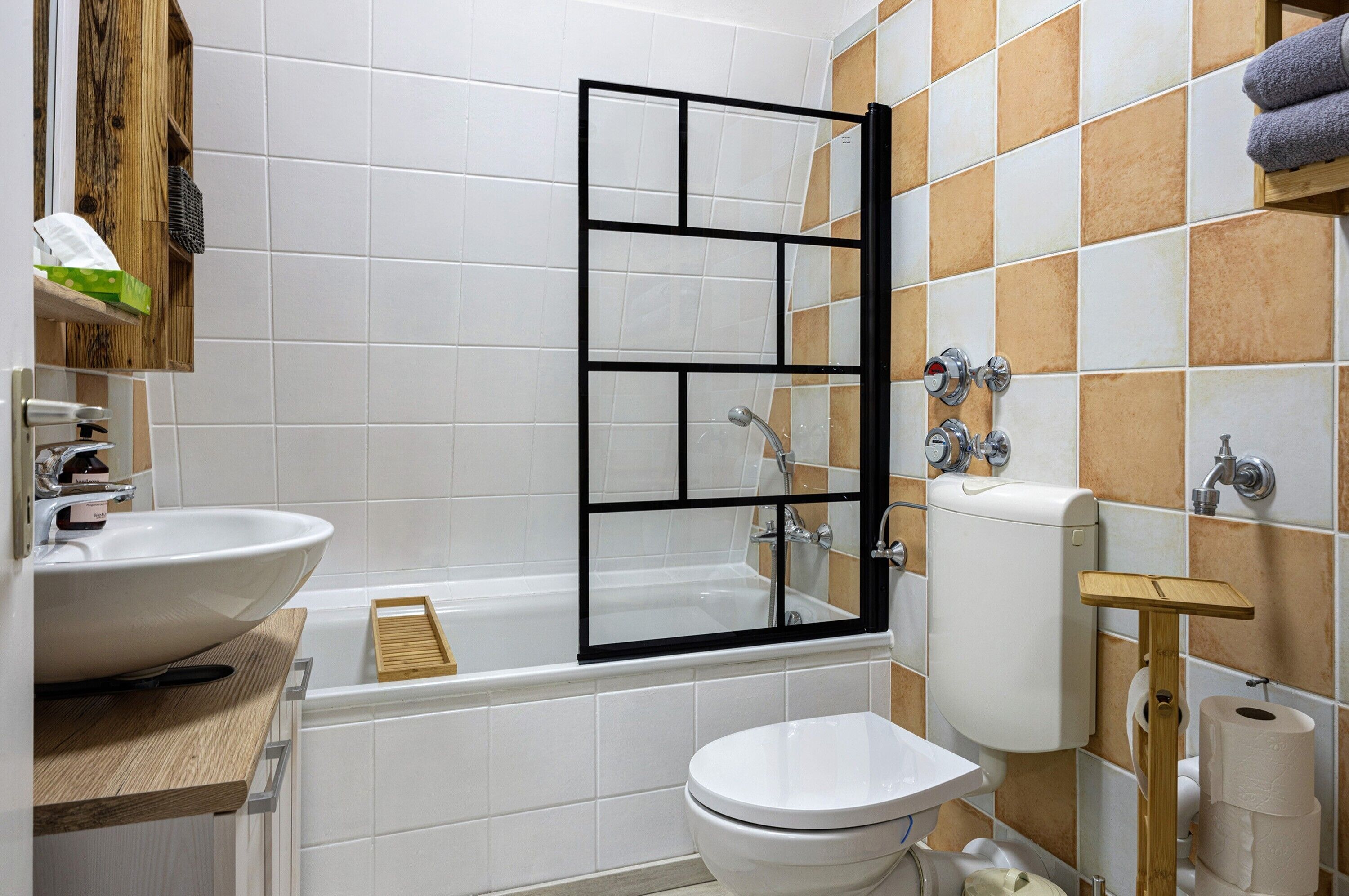 A bathroom with a bathtub, toilet, and sink.