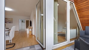 A modern interior with a dining area, a kitchen, and a living space with a wooden ceiling. - Apartment 'Ferienwohnung Berti' with Balcony and Infrared Sauna (Heeßen)