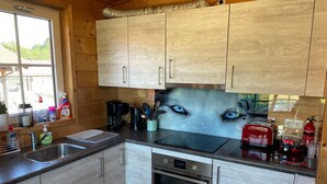 A kitchen with wooden cabinets, a stainless steel sink, a coffee maker, and a toaster. - Holiday Home 'Wolfshütte' with Private Terrace, Garden and Wi-Fi (Hillesheim)