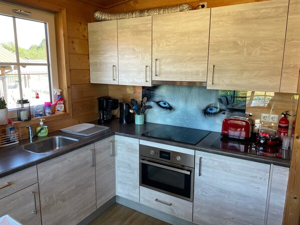 A kitchen with wooden cabinets, a stainless steel sink, a coffee maker, and a toaster. - Holiday Home 'Wolfshütte' with Private Terrace, Garden and Wi-Fi (Hillesheim)