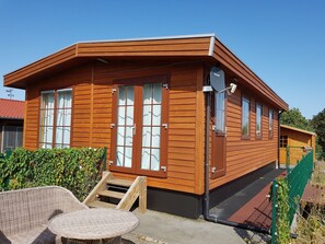 A wooden cabin with large windows, a small porch, and a staircase leading to the entrance. - Holiday Home 'Wolfshütte' with Private Terrace, Garden and Wi-Fi (Hillesheim)