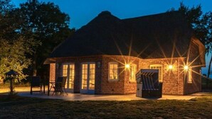 A brick building with a sloped roof, large windows, and outdoor seating. - Holiday Home 'Lüthjes Friesenhaus' with Private Terrace, Garden and Wi-Fi (Rodenäs)