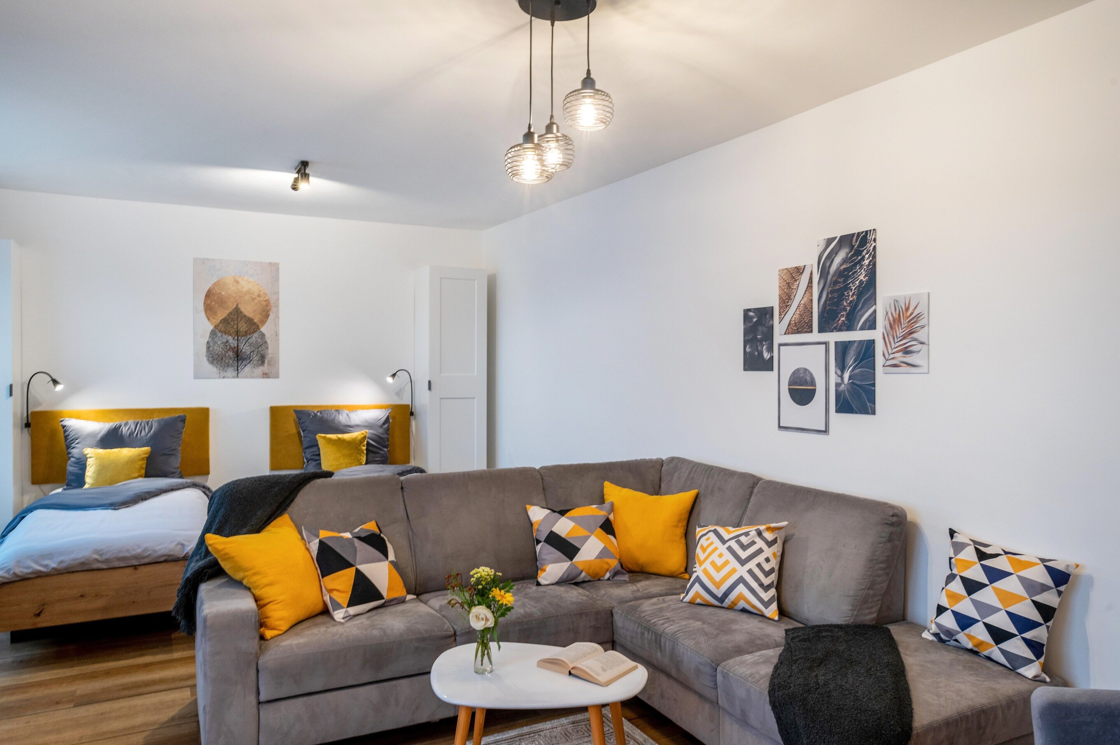 Ein modernes Wohnzimmer mit einer Couch, einem Couchtisch und einem Bett mit passenden Kopfteilen.