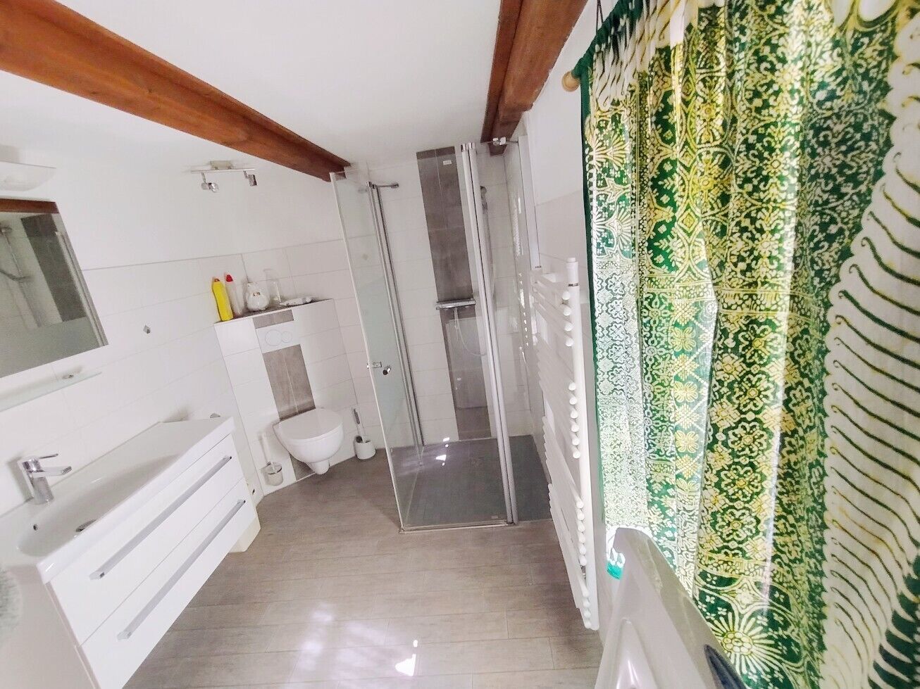A bathroom with a shower, toilet, and sink.
