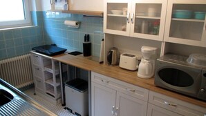 Una cocina equipada con tostadora, cafetera, microondas y armarios.