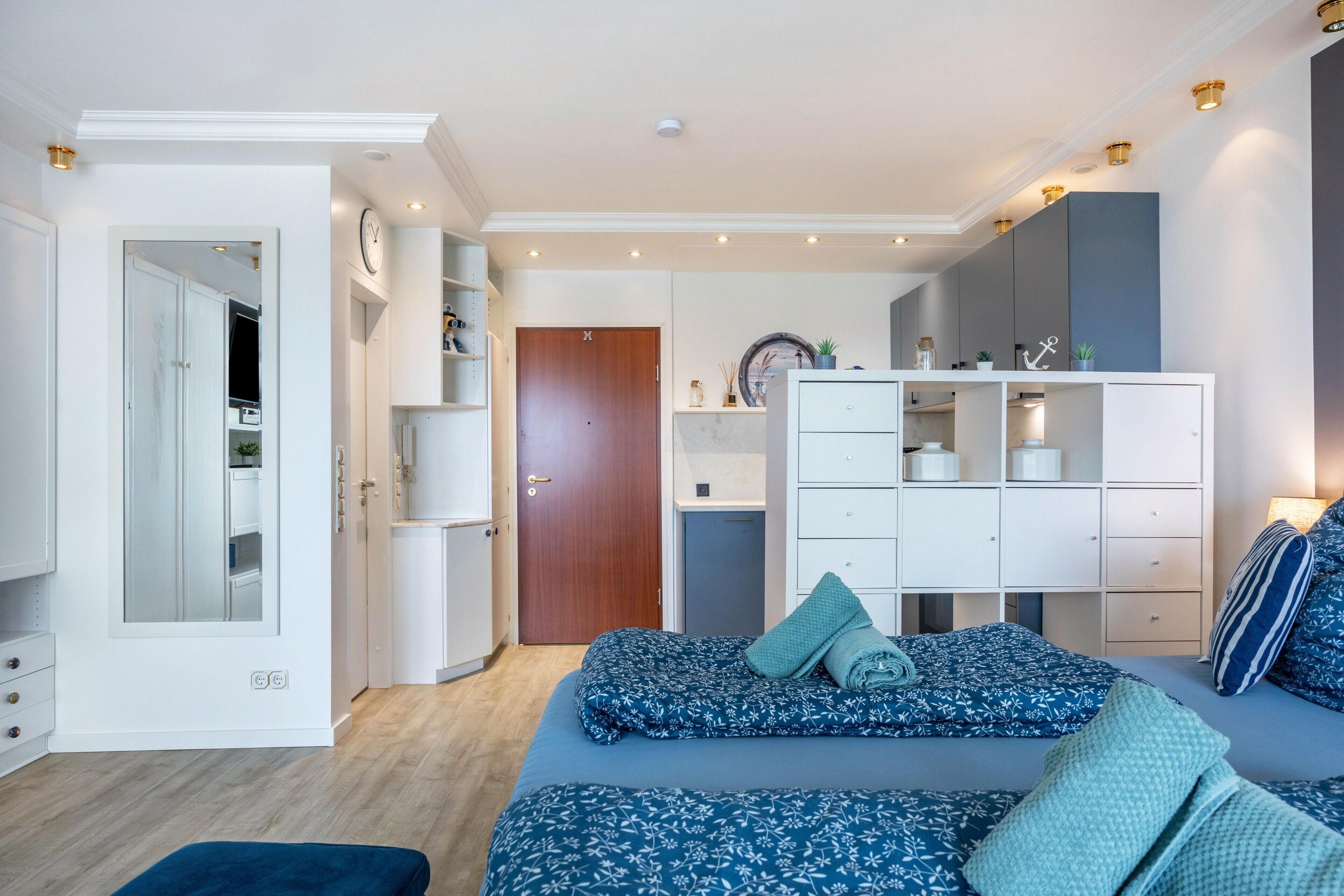 Une chambre à coucher avec un lit, une armoire, un bureau et un miroir.
