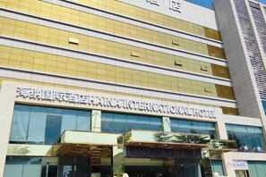 A hotel with a modern facade, large windows, and a prominent sign indicating it is an international hotel. - Yongji Haina International Hotel (Yongji)