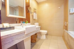 Un baño moderno con un espejo grande, dos lavamanos, un inodoro y una zona de ducha.