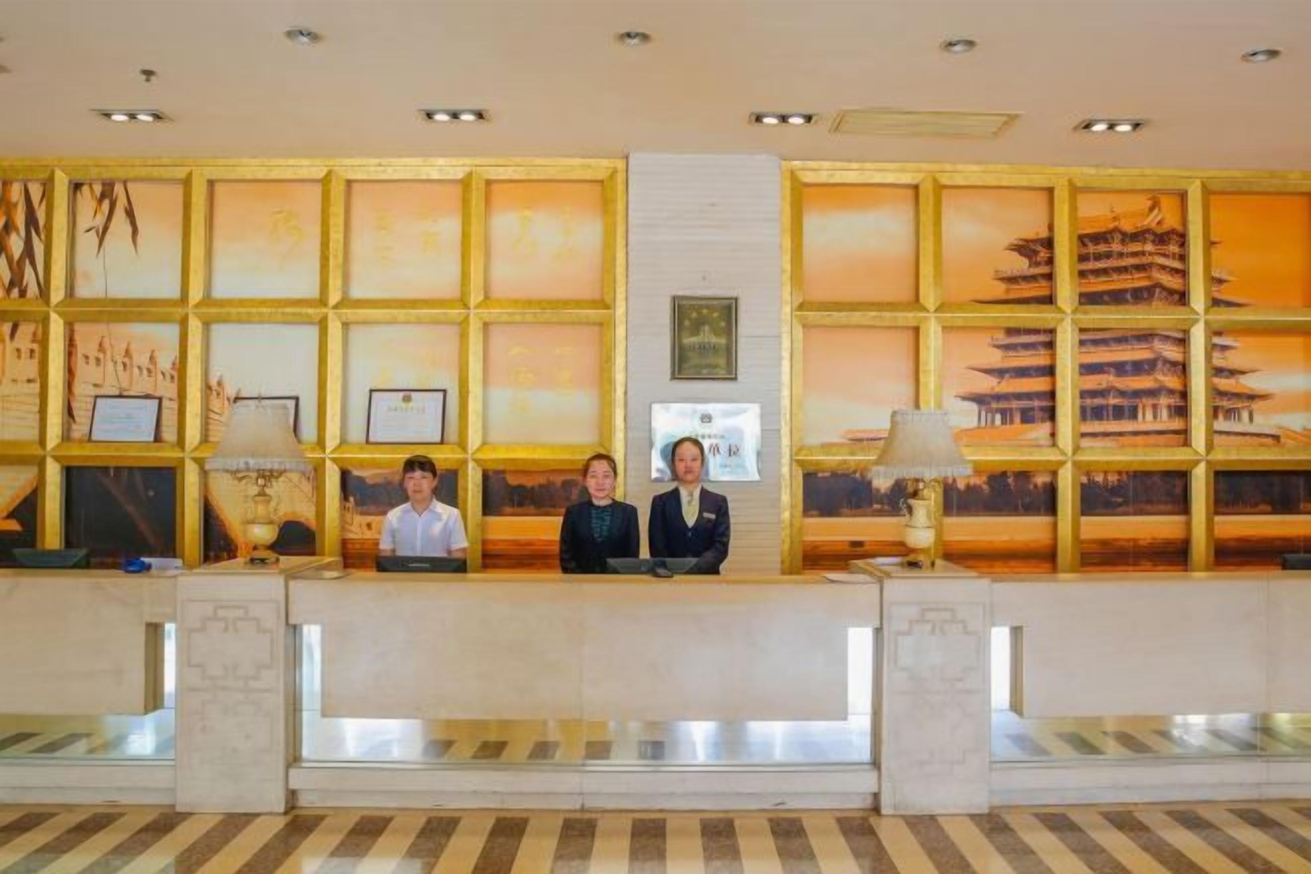 A reception desk with framed artwork and a view of a traditional building.