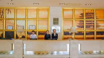 A reception desk with framed artwork and a view of a traditional building.