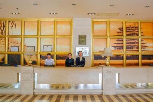 Un mostrador de recepción con obras de arte enmarcadas y vistas a un edificio tradicional.