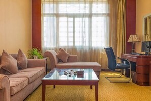 Une chambre d’hôtel équipée d’un canapé, d’une table basse, d’un bureau et d’une chaise.