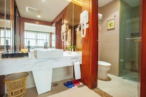 A modern bathroom with a large mirror, a white sink, a glass shower enclosure, and a toilet. - Yongji Haina International Hotel (Yongji)