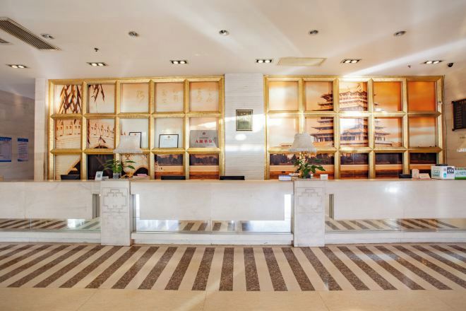 A reception area with a marble counter, wooden display panels, and a striped carpet.