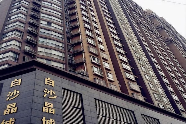 Ein Hochhaus mit mehreren Balkonen und einem Schild mit chinesischen Schriftzeichen.