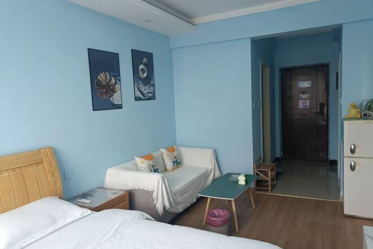 Een hotelkamer met twee bedden, een klein tafeltje, een stoel en een kledingkast.