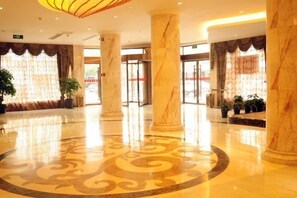 A spacious lobby with marble columns, a patterned floor, and large windows with curtains. - Haoting Motel (Pingyang)