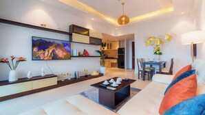 A modern living room with a sofa, coffee table, and a TV mounted on the wall.