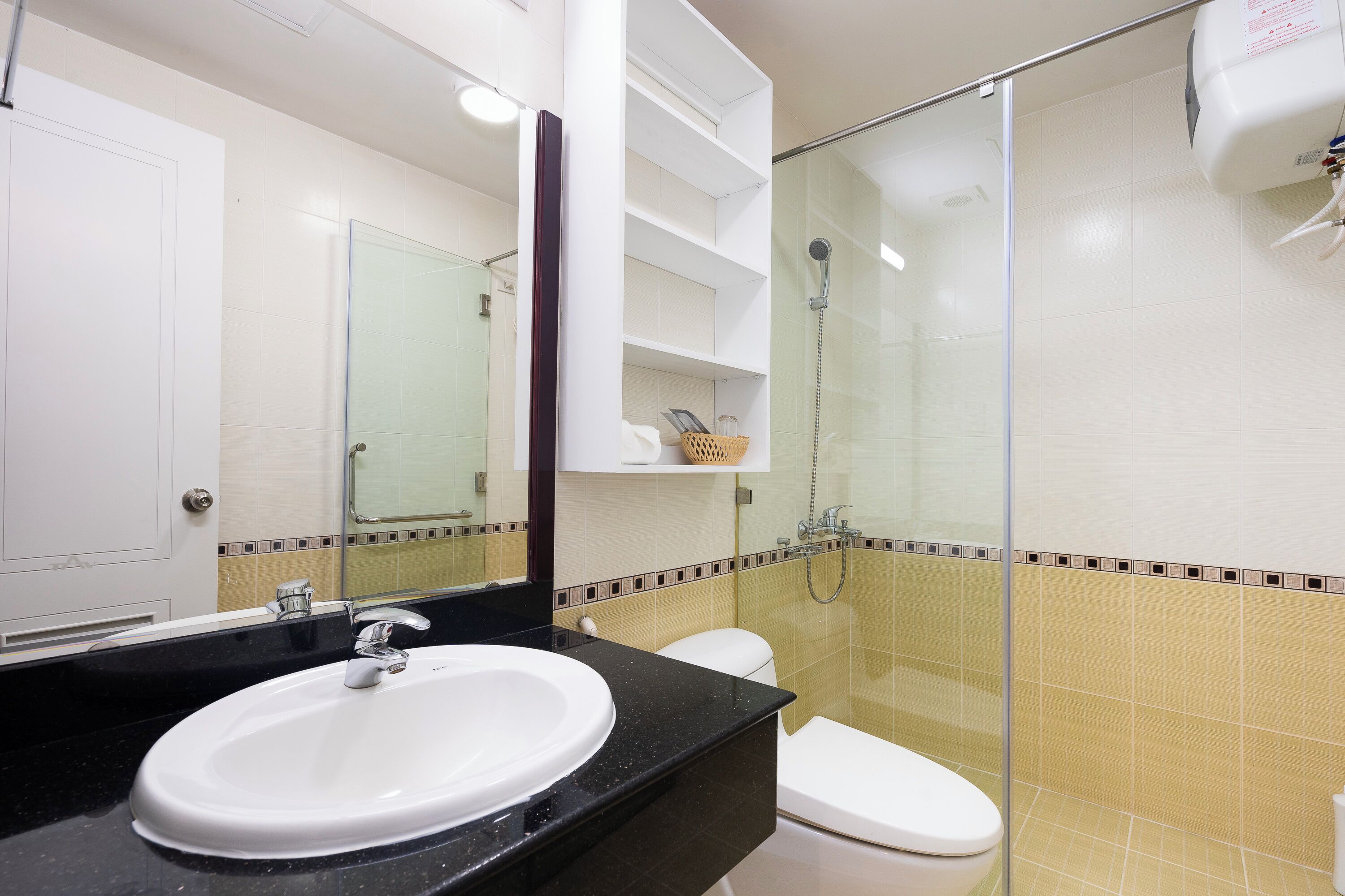 Un baño con lavamanos blanco, inodoro y cabina de ducha de vidrio.