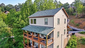 A two-story house with a balcony on the ground floor and a second-floor balcony. - 
Smoky Mountain Cabin; 3 King Suites; Hot Tub; Game Room; Sleeps 12 (Sevierville)