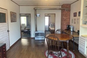 A room with a dining table, chairs, a radiator, a bed, and a kitchen area. - spacious room close to JR station Free WIFI parking lot (Ebetsu)