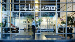 Un edificio moderno con fachada de vidrio y el nombre "THE LANCASIER" exhibido en grande.