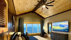 Une chambre avec un grand lit, une télévision et une vue sur l’extérieur.