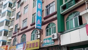 A multi-story building with various commercial establishments on the ground floor, including a pharmacy and a restaurant. - Huaiji Tianyuan Travel Industry (Huaiji)