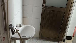 A bathroom with a sink, a toilet, and a shower. - Huaiji Tianyuan Travel Industry (Huaiji)