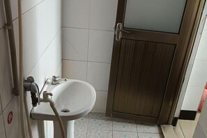 A bathroom with a sink, a toilet, and a shower. - Huaiji Tianyuan Travel Industry (Huaiji)