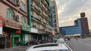 A street view with a row of shops and a building with multiple floors. - Huaiji Tianyuan Travel Industry (Huaiji)