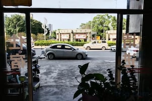 Vista a través de una ventana que muestra una escena urbana, con coches estacionados y edificios.
