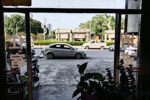 A view through a window with a street scene, including parked cars and buildings.