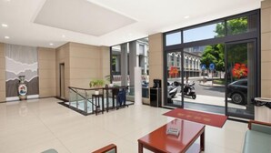 A hotel lobby with a reception desk, seating area, and large windows offering a view of the street. - Park Hyatt Fashion Hotel (Kaili cross street people's hospital) (Kaili)
