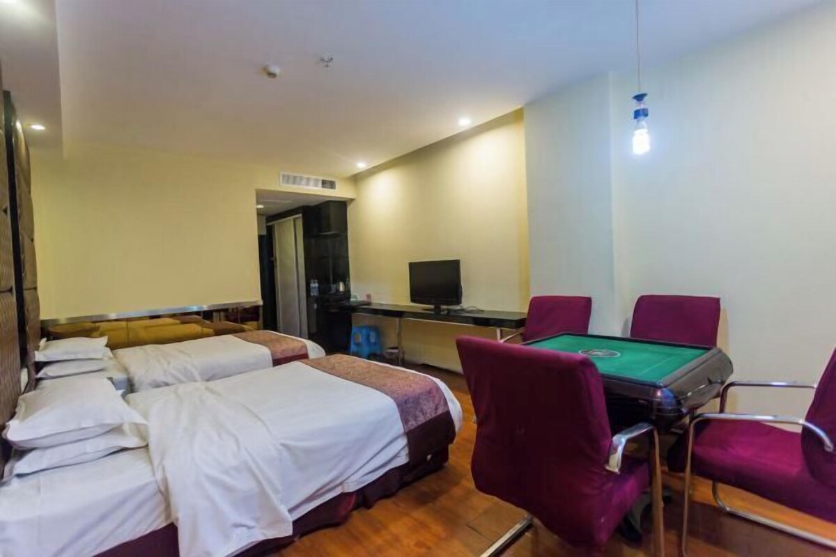 A hotel room with two beds, a pool table, and a television.
