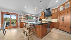 Un'ampia cucina con mobili in legno, una grande isola e vista all'esterno.