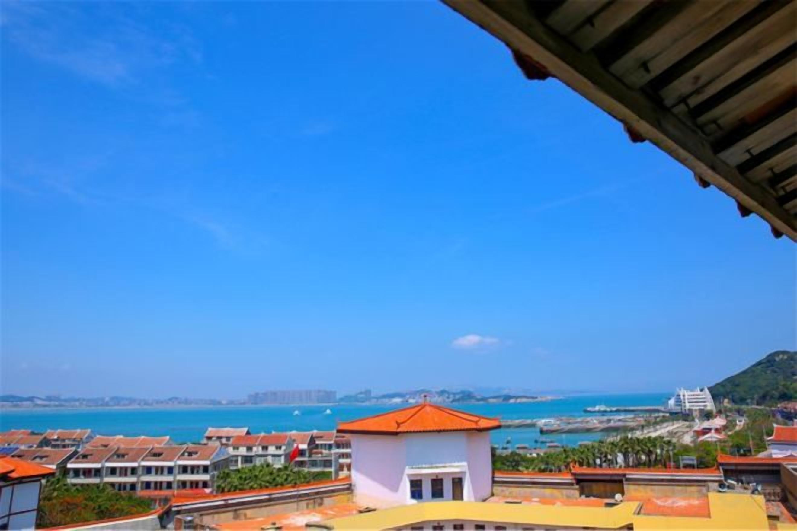 A coastal view with buildings, a clear sky, and a distant shoreline.