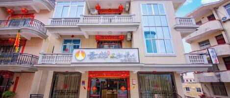A multi-story building with a storefront featuring a red awning and a sign with Chinese characters.