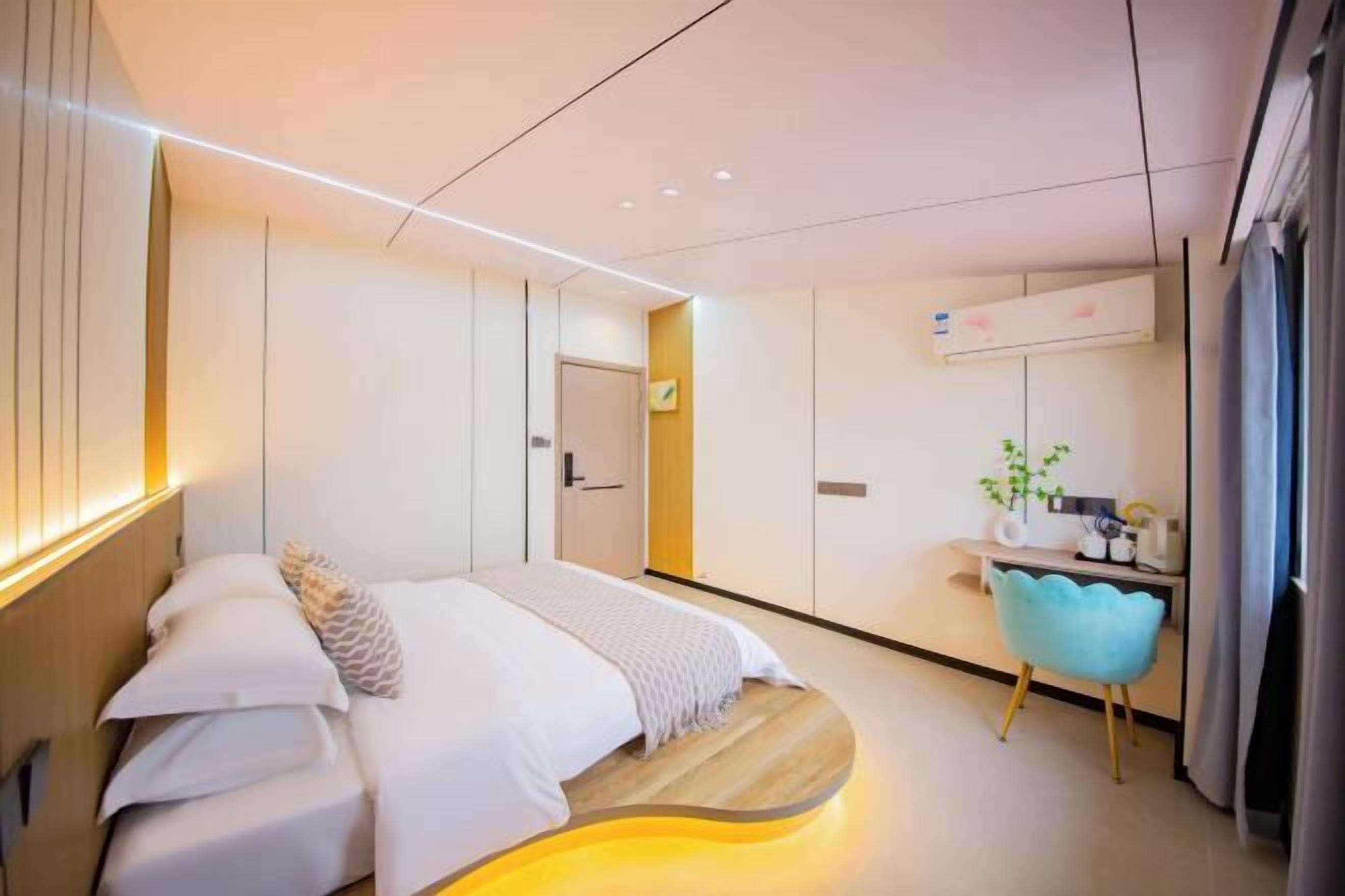 A modern bedroom with a bed, bedside table, and a desk with a chair.