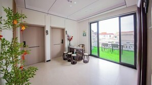 Un intérieur moderne comprenant un coin repas, de grandes fenêtres et une vue sur l’extérieur.